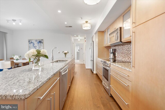 675 President St Unit 1406, Baltimore, MD 21202 - kitchen with a sink, appliances with stainless steel finishes, light wood-style flooring, a large island with sink, and light brown cabinetry