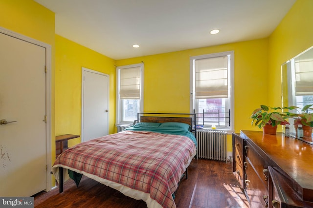 bedroom with radiator heating unit and dark wood-type flooring