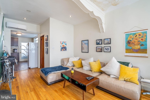 living room with light hardwood / wood-style floors, crown molding, and a wall mounted AC