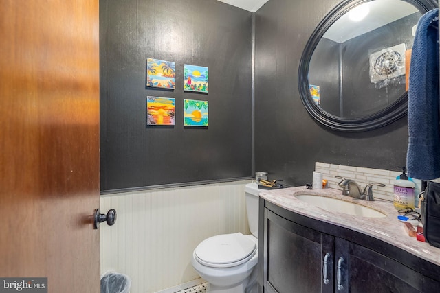 bathroom with backsplash, vanity, and toilet