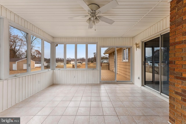 unfurnished sunroom with ceiling fan and plenty of natural light