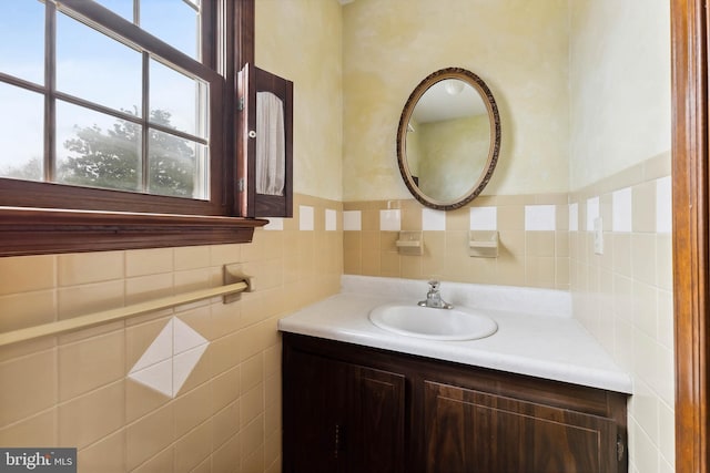 bathroom featuring vanity and tile walls