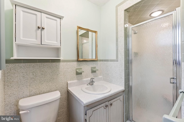 bathroom with vanity, toilet, tile walls, and walk in shower