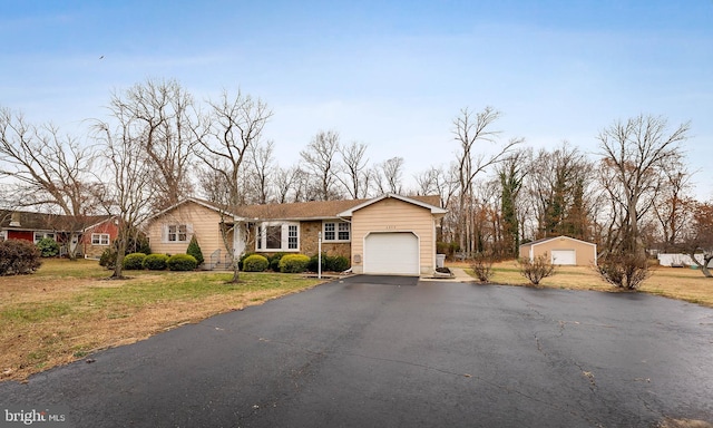 view of front of home featuring a front yard, an outbuilding, and a garage