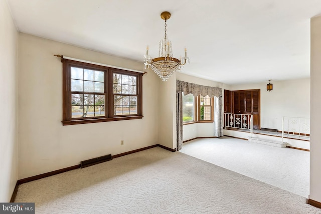 unfurnished room with carpet floors and an inviting chandelier