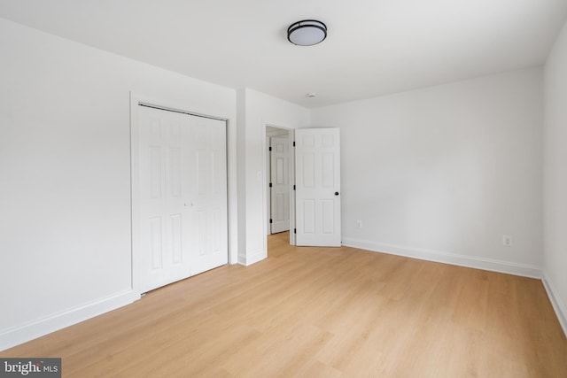 unfurnished bedroom with a closet and light hardwood / wood-style flooring