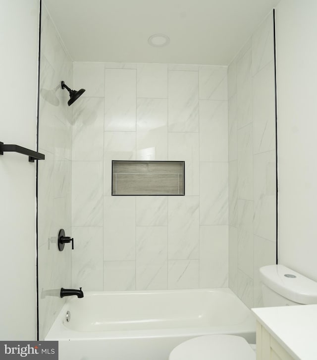 full bathroom featuring toilet, tiled shower / bath, and vanity