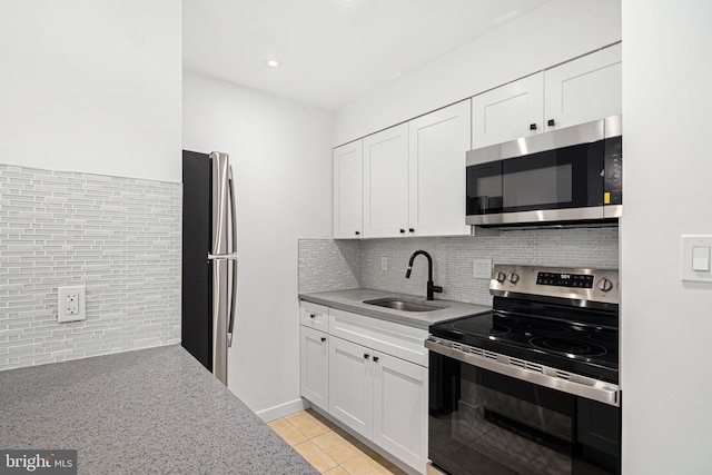 kitchen featuring white cabinets, decorative backsplash, sink, and appliances with stainless steel finishes