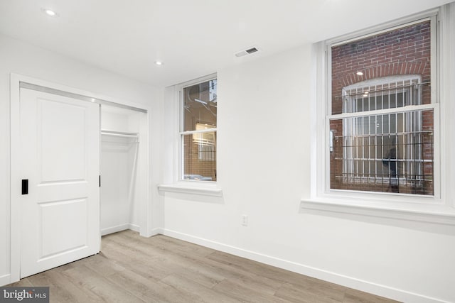 unfurnished bedroom with a closet and light hardwood / wood-style flooring