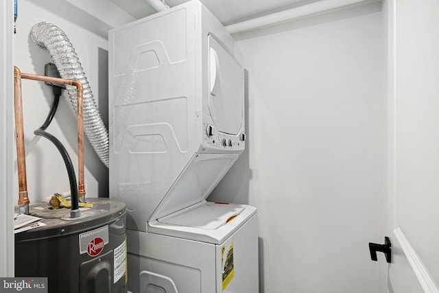 clothes washing area with stacked washer and clothes dryer and water heater