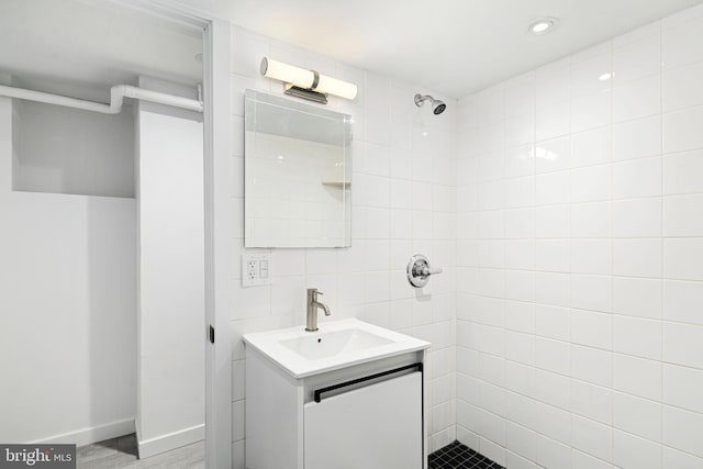 bathroom featuring tiled shower, hardwood / wood-style floors, and vanity