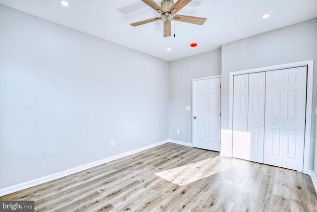 unfurnished bedroom featuring a closet, light hardwood / wood-style flooring, and ceiling fan