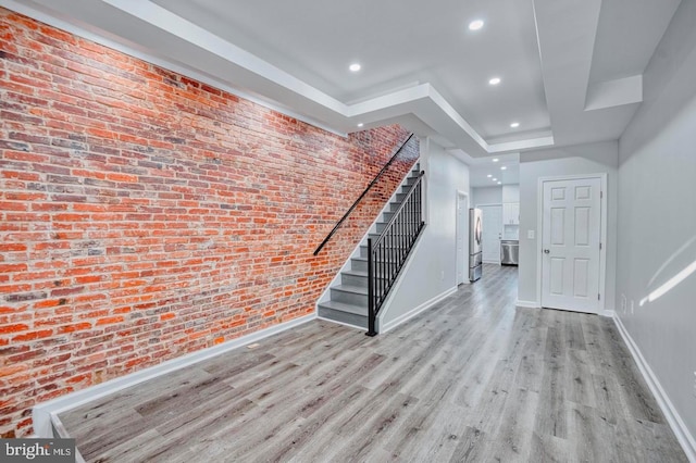 interior space with brick wall and light wood-type flooring