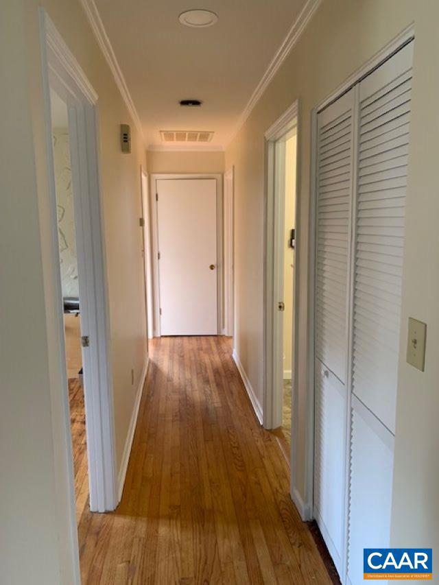 hallway with crown molding and hardwood / wood-style flooring