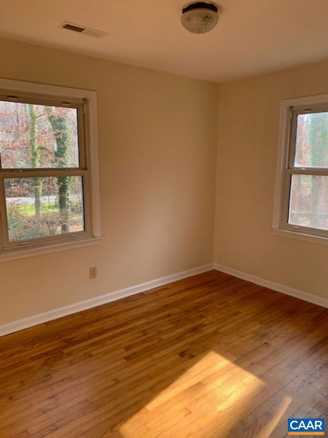 unfurnished room with hardwood / wood-style flooring