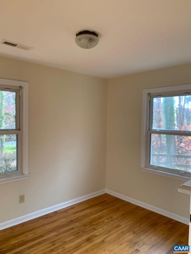 spare room with plenty of natural light and light hardwood / wood-style floors