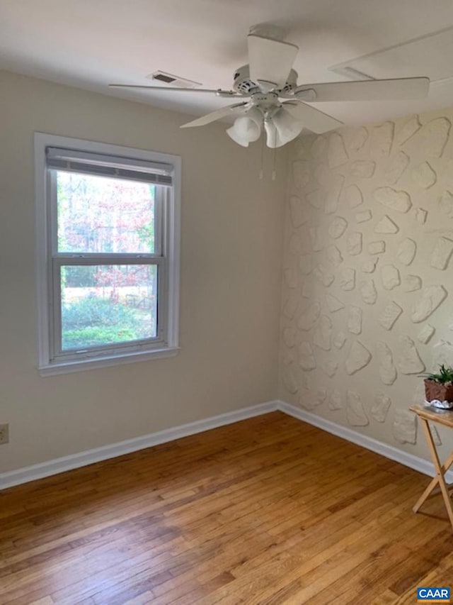 spare room with ceiling fan and light wood-type flooring