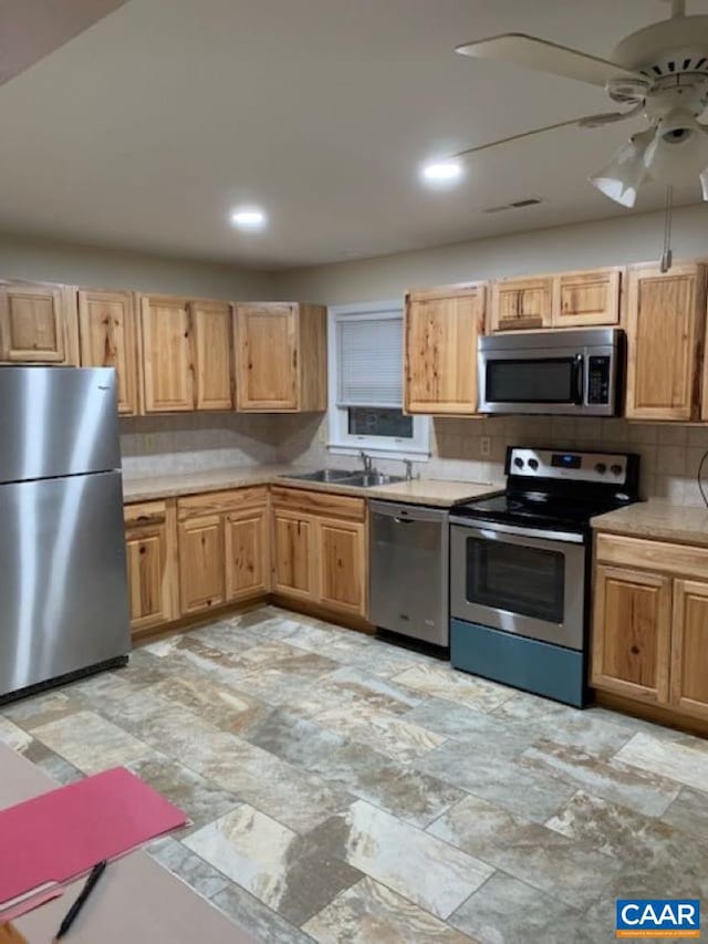 kitchen featuring ceiling fan, stainless steel appliances, sink, and decorative backsplash