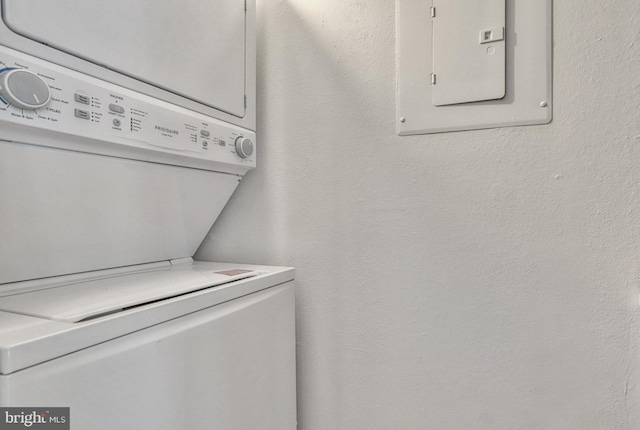 laundry room with stacked washing maching and dryer and electric panel