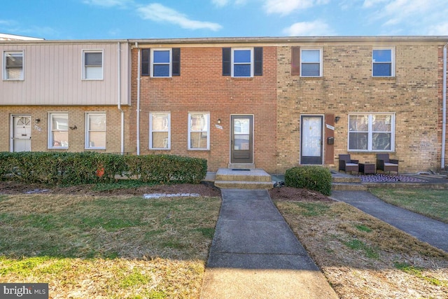 view of property with a front lawn and brick siding