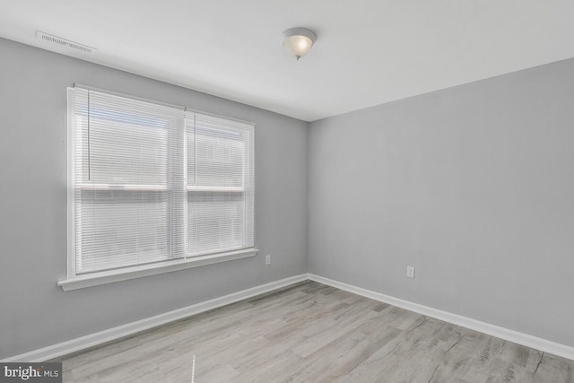 spare room with visible vents, light wood-style flooring, and baseboards