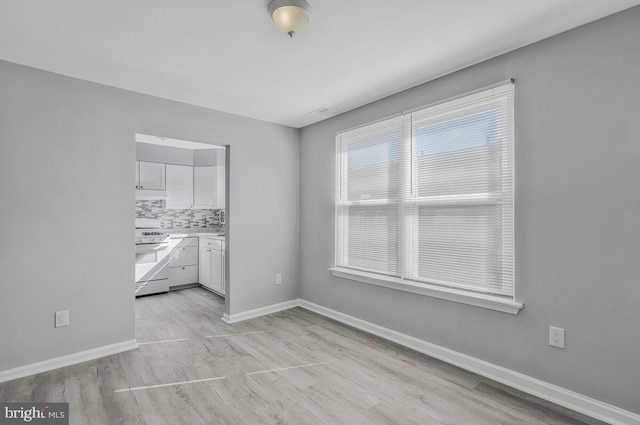 empty room with light wood-style flooring and baseboards