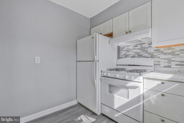 kitchen with decorative backsplash, white cabinets, white appliances, premium range hood, and baseboards