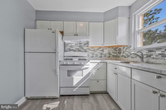 kitchen featuring light countertops, white appliances, exhaust hood, and white cabinetry