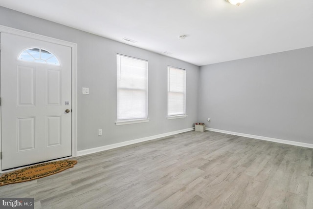 foyer featuring baseboards, visible vents, and light wood finished floors