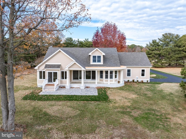 rear view of property with a lawn and a sunroom