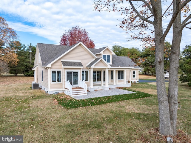 back of property with a yard and central AC