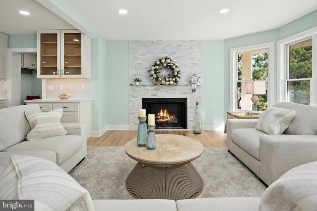 living room with light wood-type flooring and a fireplace