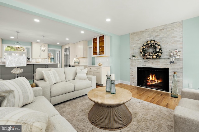 living room with light hardwood / wood-style flooring and a brick fireplace