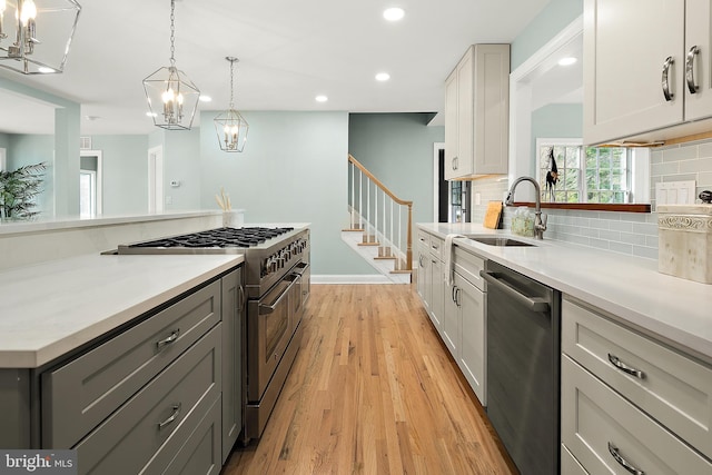 kitchen featuring white cabinetry, sink, stainless steel appliances, and light hardwood / wood-style floors