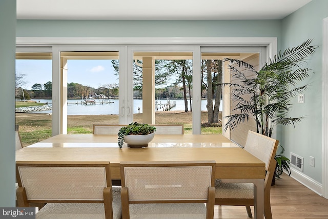 dining space with a water view and wood-type flooring