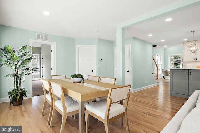 dining space with a chandelier and light hardwood / wood-style flooring