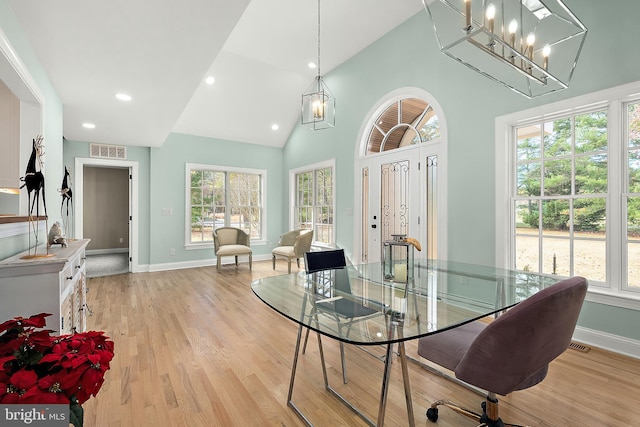 dining space featuring a wealth of natural light, high vaulted ceiling, and light hardwood / wood-style floors