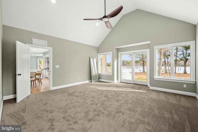 unfurnished living room with carpet flooring, ceiling fan, and high vaulted ceiling