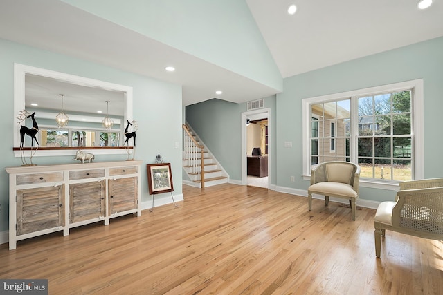 living area with wood-type flooring, vaulted ceiling, and ceiling fan