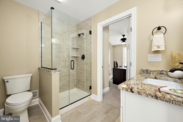 bathroom featuring ceiling fan, a shower with door, vanity, and toilet