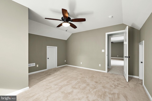 unfurnished bedroom with ceiling fan, light colored carpet, and lofted ceiling