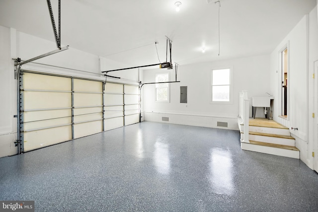 garage featuring electric panel and a garage door opener