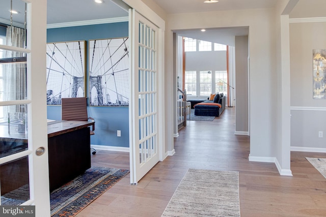 interior space with crown molding, french doors, and light hardwood / wood-style floors