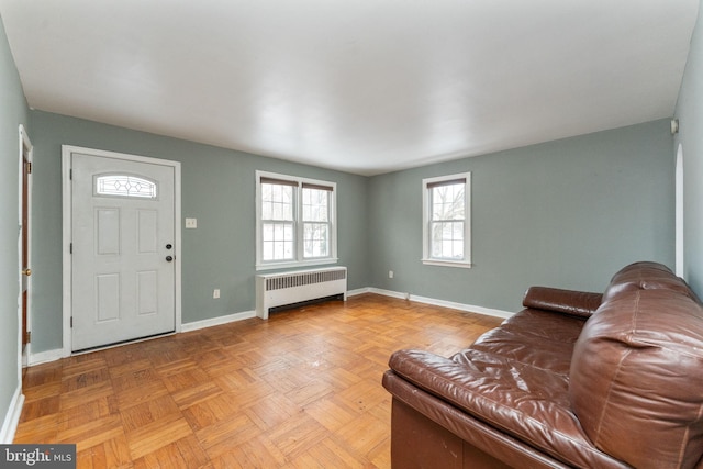 living room featuring light parquet floors and radiator heating unit