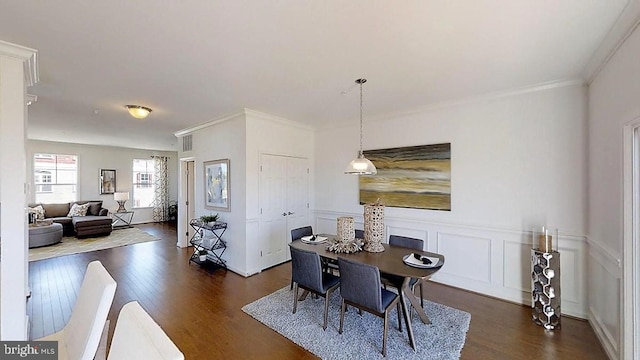 dining space featuring dark hardwood / wood-style floors and crown molding