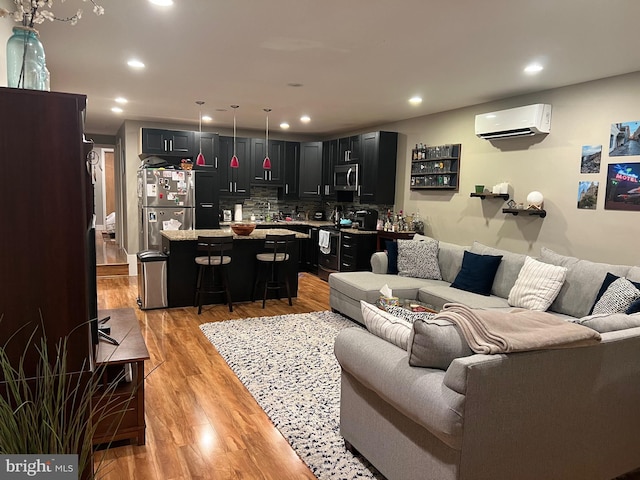 living room featuring light hardwood / wood-style floors and a wall mounted AC