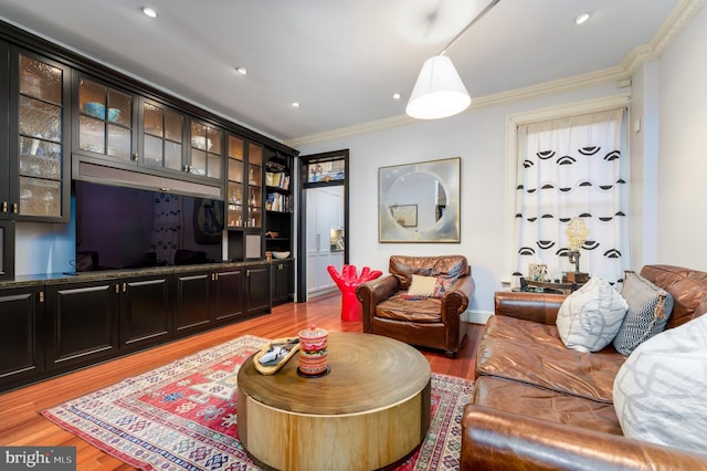 living room with ornamental molding and light hardwood / wood-style flooring