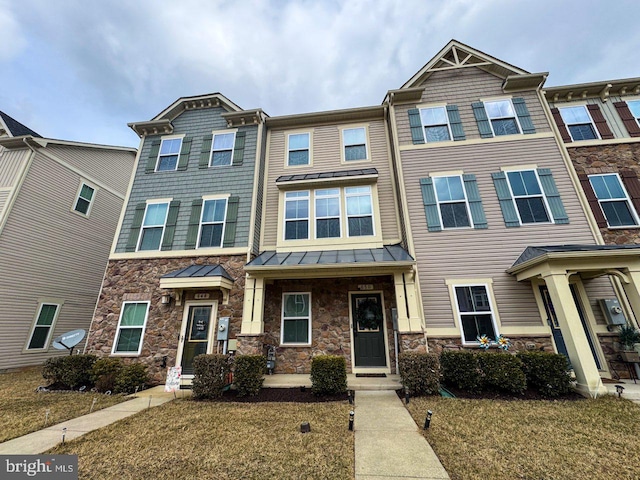 townhome / multi-family property with a standing seam roof, stone siding, and metal roof