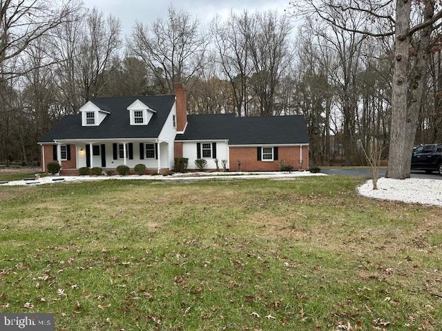 cape cod home with a front yard