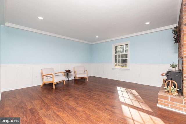 sitting room with dark wood-type flooring and ornamental molding